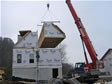 Installation of the fourth modular section on a walk out basement foundation