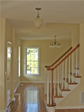 Open foyer looks past the rounded baluster stair railings into the living room of this modular home