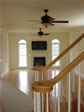 An elegant view into the living room from the front door shows a double oak railing staircase 